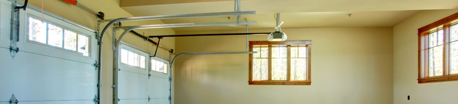 Spacious two-car garage with modern electric garage doors, ceiling-mounted openers, and natural light, illustrating electric garage door services in Treasure Island.