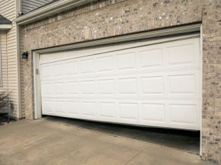 Emergency Garage Door Repair Service – Treasure Island White residential garage door stuck halfway open, illustrating an urgent garage door repair situation in Treasure Island.