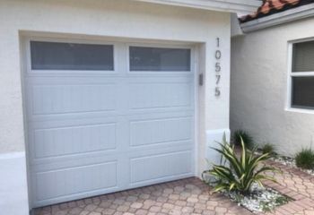 Side angle of a new white garage door with frosted windows and clean trim, highlighting detailed installation work in Clearwater.