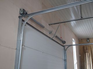 Garage Door Spring Repair – Treasure Island Close-up view of a garage door torsion spring and metal track system inside a residential garage, illustrating professional garage door spring repair in Treasure Island.