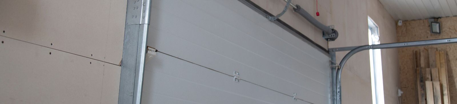 Close-up view of a garage door torsion spring and metal track system inside a residential garage, illustrating professional garage door spring repair in Treasure Island.