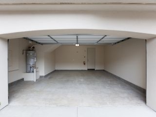 Innovative Technologies for Garage Doors – Garage Door Repair Treasure Island Blog Interior view of a modern, empty garage with an open overhead garage door and visible automatic opener, illustrating innovative garage door technologies
